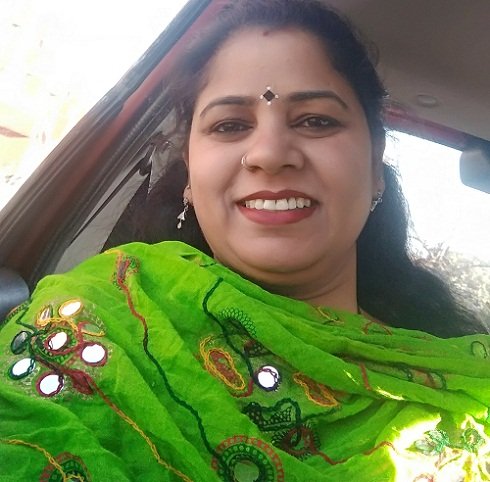 Portrait of Dr. Kapoor wearing traditional attire with academic books in background